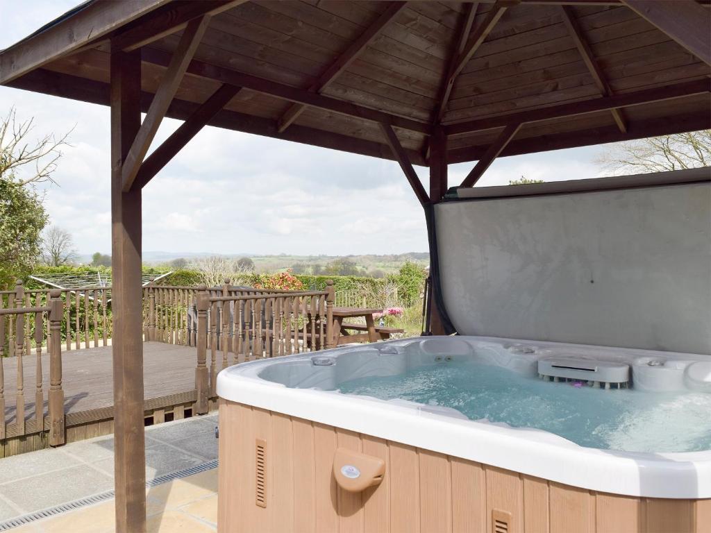 a hot tub on a patio with a wooden deck at Green Haven in Narberth