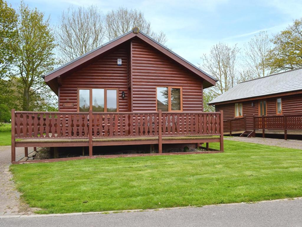 a wooden cabin with a bench in front of it at Fairways Lodge in Bridlington