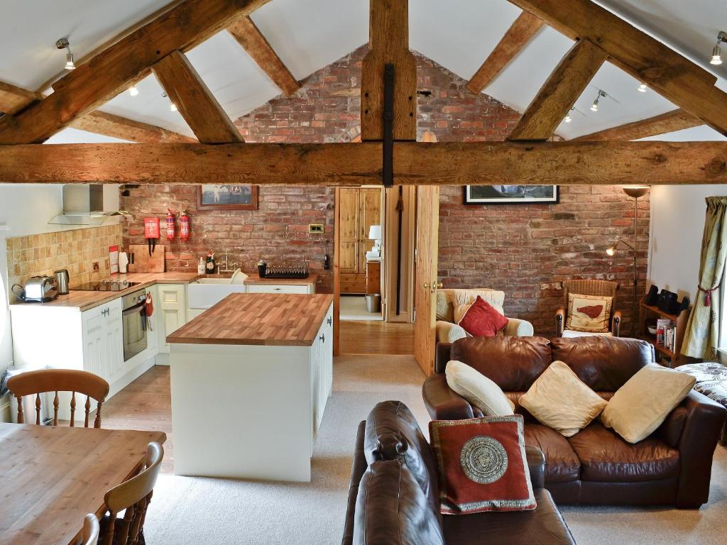 a kitchen and living room with a couch and a table at The Old Stables in Helsby