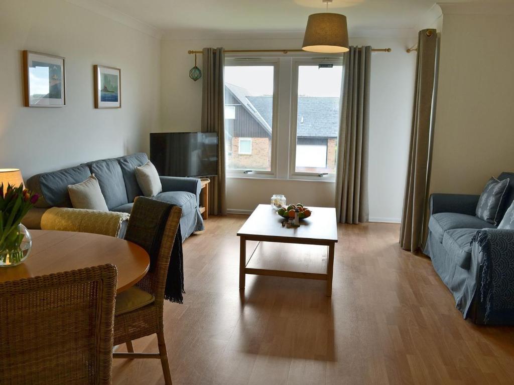 a living room with a couch and a table at Sandy View in Beadnell