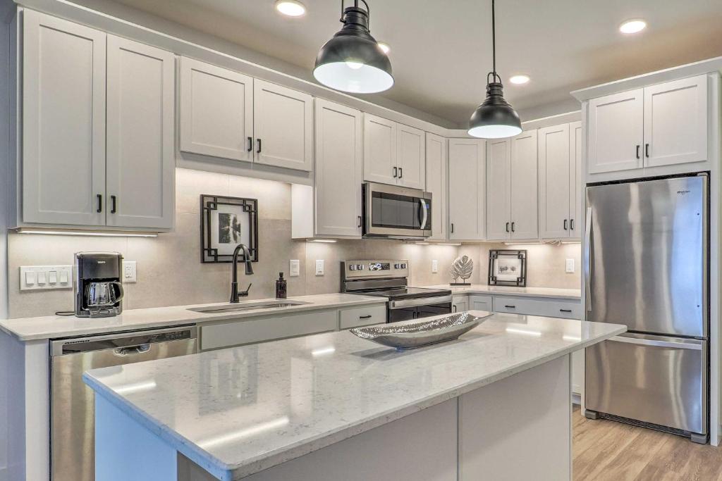 a kitchen with white cabinets and stainless steel appliances at Winter Escape! Downtown Traverse City Condo in Traverse City