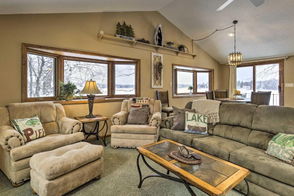 Una sala de estar con sofás y sillas y una mesa. en Phillips Cabin with Lake Views and Private Dock!, en Phillips
