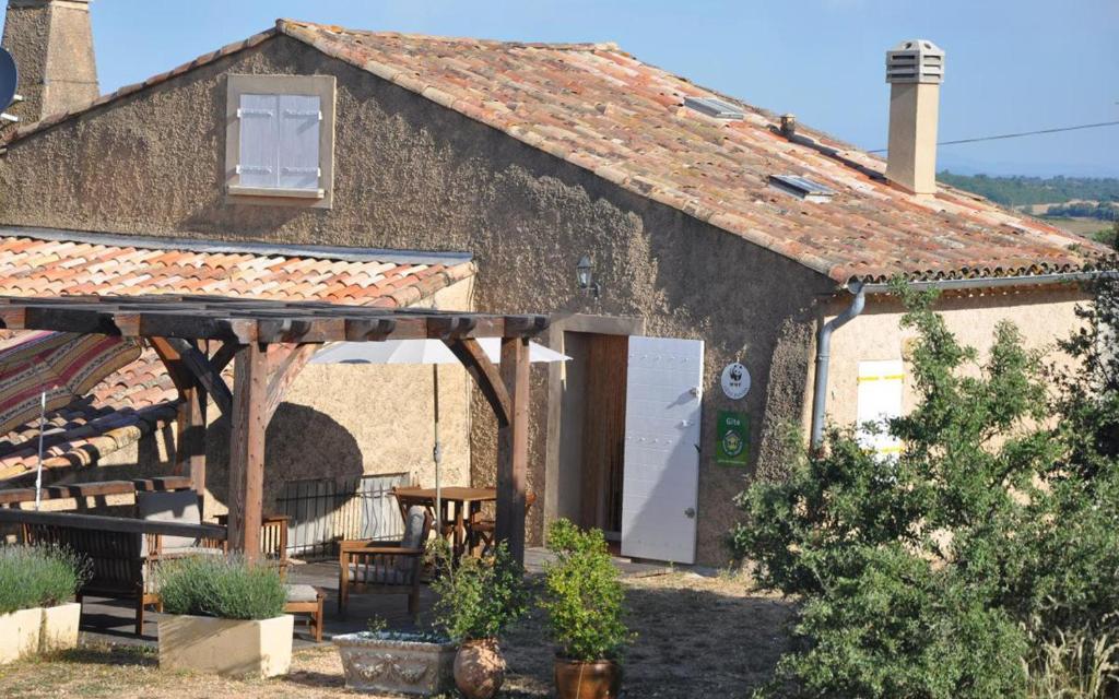 een gebouw met een tafel en stoelen ervoor bij Gite "panda" la vincence in La Verdière