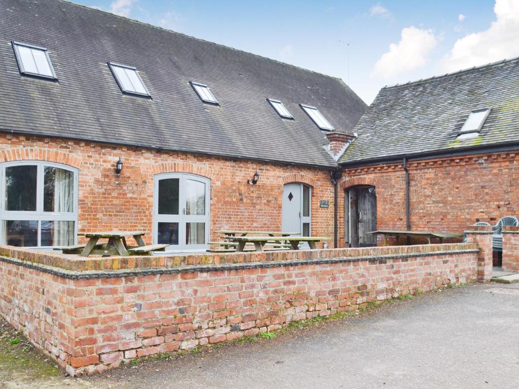 a brick building with a picnic table in front of it at The Stables in Somersal Herbert