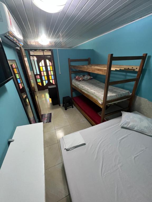 a room with two bunk beds and a table at Kitnets com AR Condicionado na Praia in Salvador