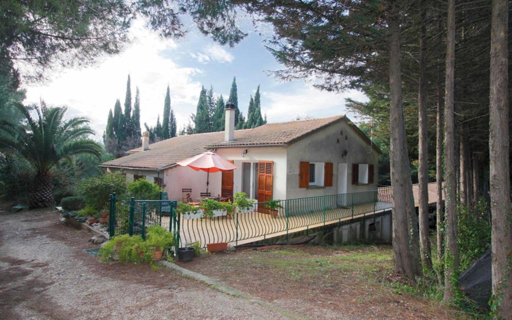 a small white house with an umbrella and trees at La bayorre in Hyères