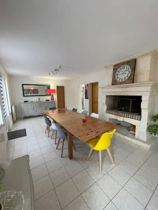 une salle à manger avec une table et une cheminée dans l'établissement Maison bord de mer Chez JuJu, à Grandcamp-Maisy
