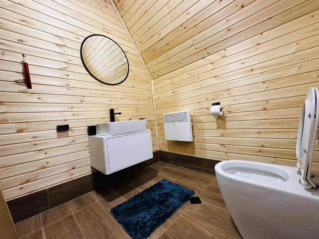 ein Badezimmer mit einem weißen Waschbecken und einem Spiegel in der Unterkunft WinterFell Mestia in Mestia