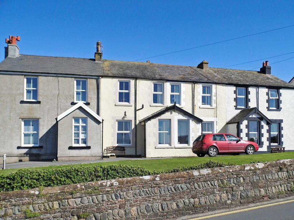 a house with a red car parked in front of it at Shingle Cottage in Seascale