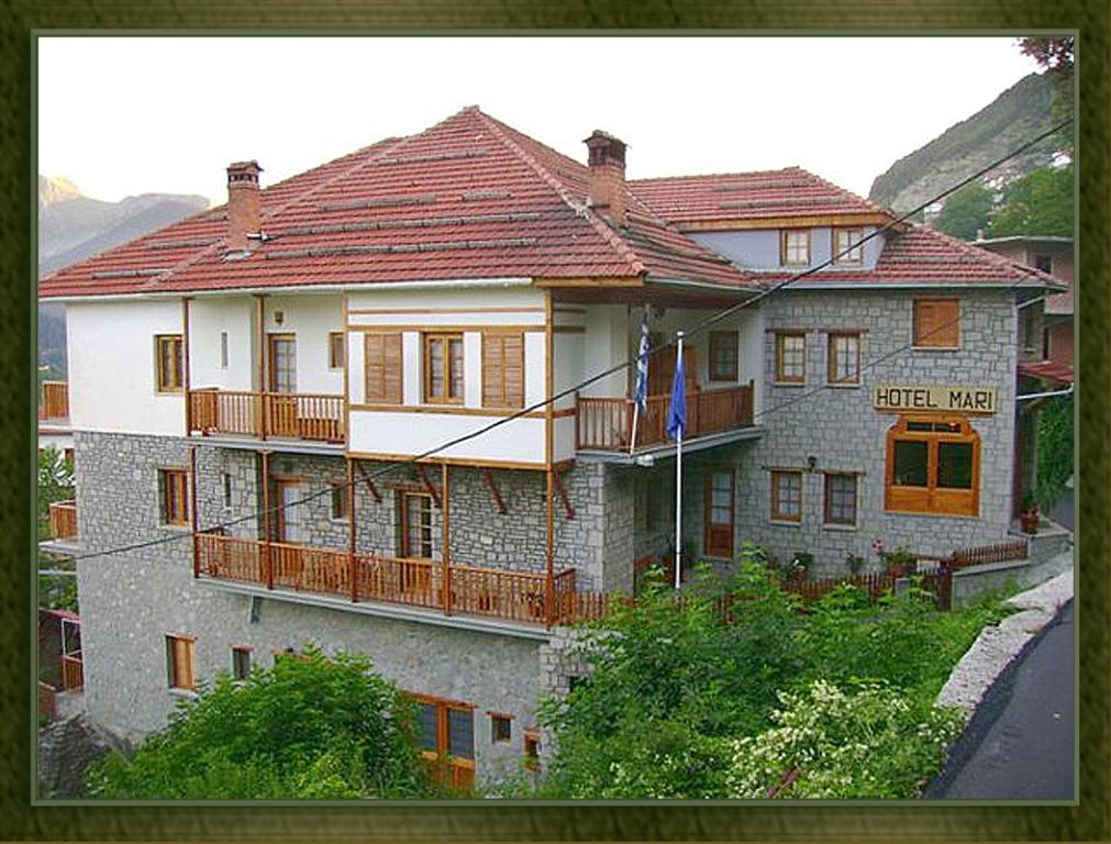 um grande edifício de pedra com uma bandeira em frente em HOTEL MARI Metsovo em Metsovo