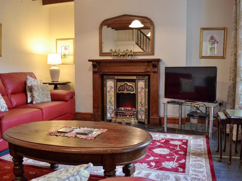 sala de estar con sofá y chimenea en Smithy House en Betws-y-coed