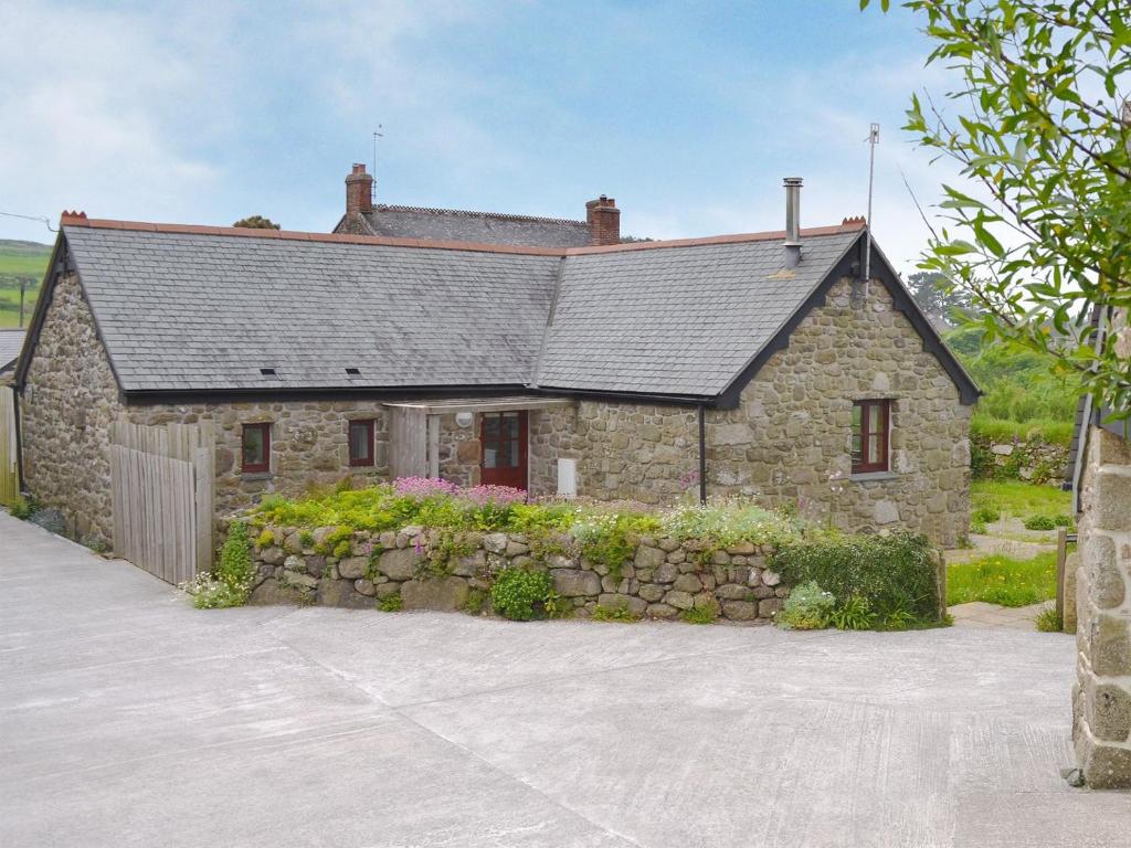 a stone house with a stone wall at Sparrows in Morvah