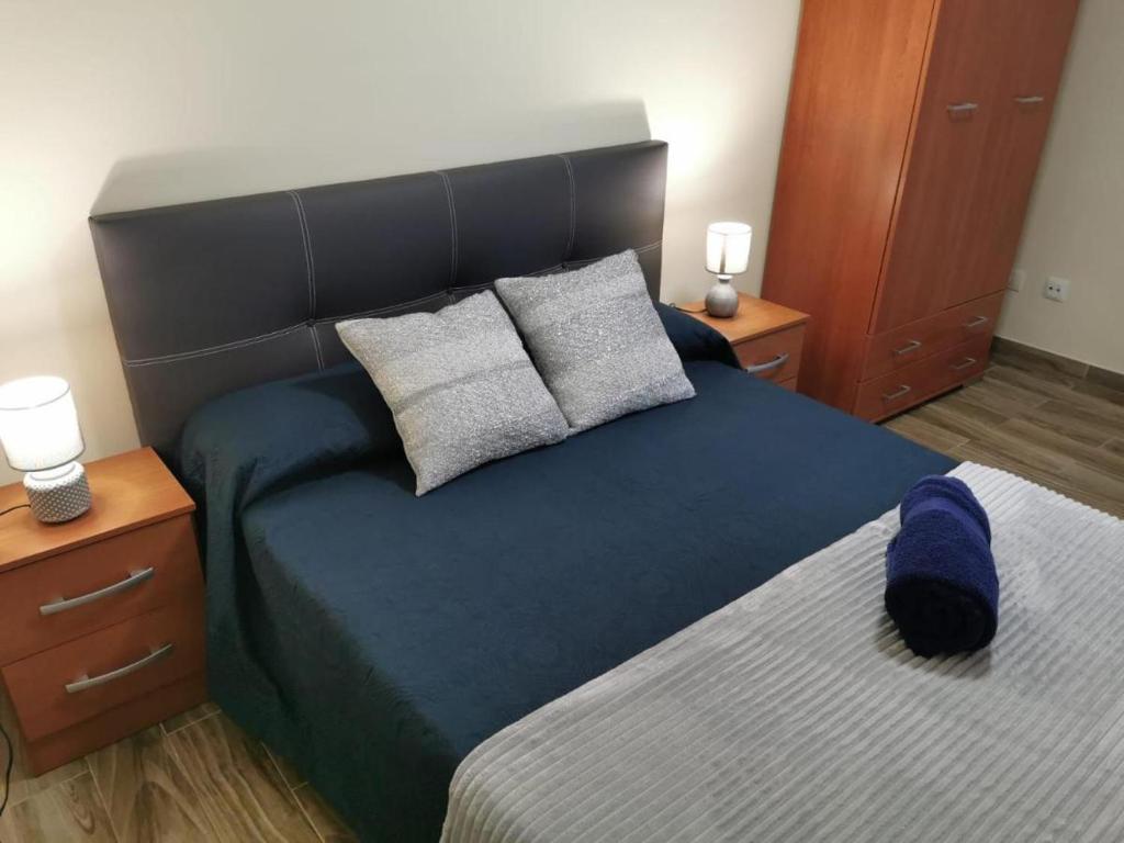 a bedroom with a large blue bed with two night stands at The Blue House in La Laguna