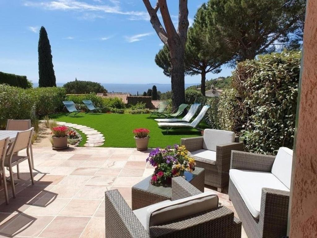 d'une terrasse avec des canapés et des chaises ainsi que d'un jardin. dans l'établissement Joli gite les palmiers iii, à La Croix-Valmer