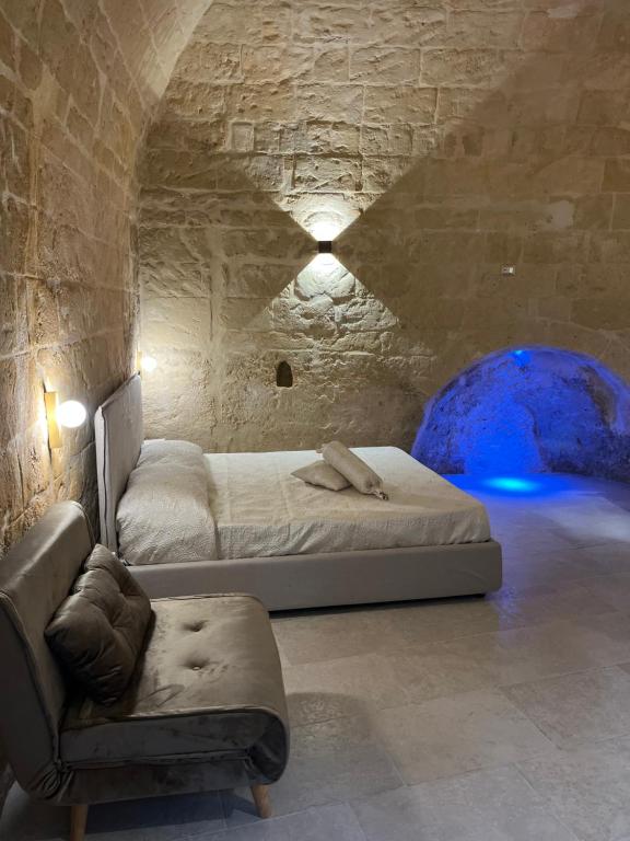 マテーラにあるLo scorcio sul Barisanoのベッドルーム1室(ベッド1台、洞窟内のソファ付)