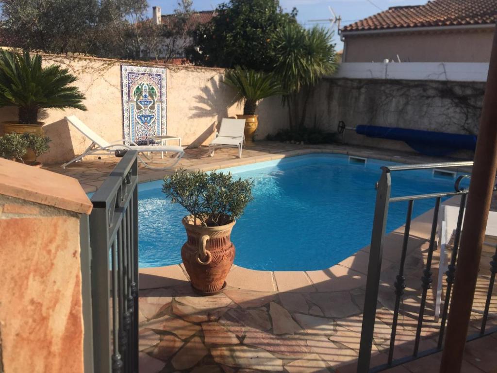 une piscine avec une plante en pot à côté d'une clôture dans l'établissement Grande villa, au Muy