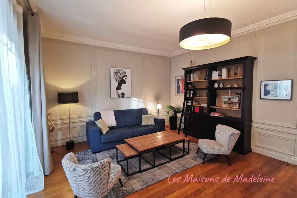uma sala de estar com um sofá azul e uma mesa em Le Royal Couëdic - Les Maisons de Madeleine em Nantes