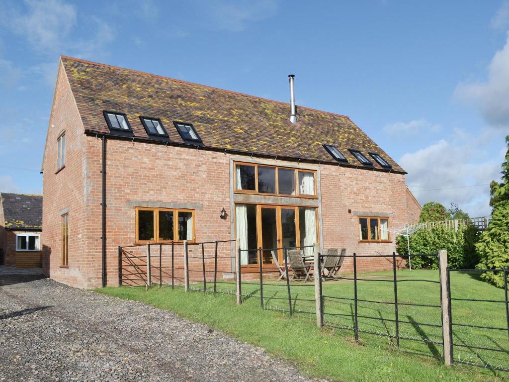 a brick house with windows on the side of it at The Old Workshop in Alderminster