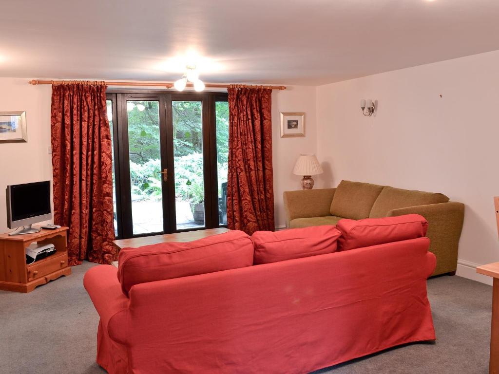 a living room with a red couch and a television at Long Mynd in Ambleside