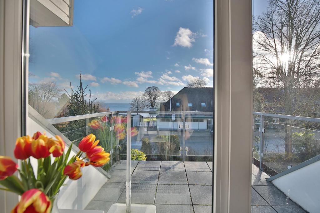 Elle offre une vue sur un balcon orné de fleurs dans un vase. dans l'établissement Haus am Seehof 6 Seehof, à Sierksdorf