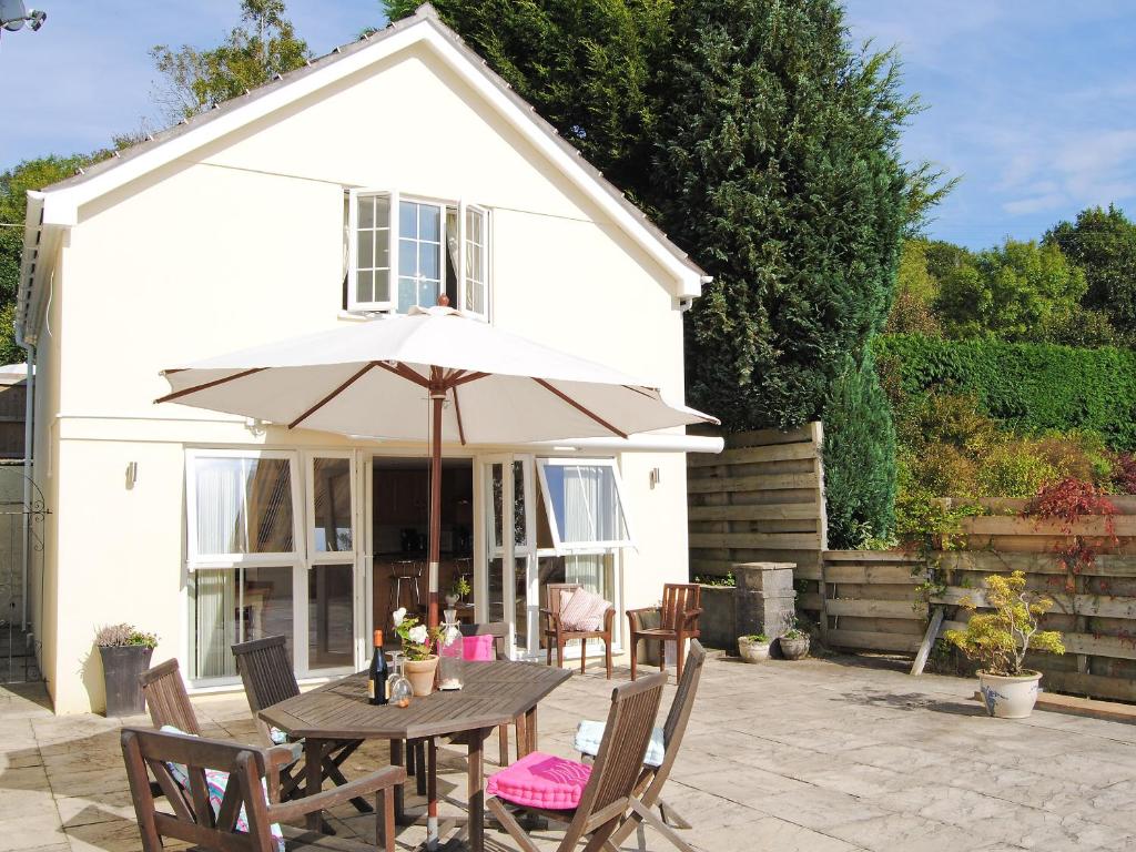 a table with an umbrella in front of a house at The Little House in Calstock