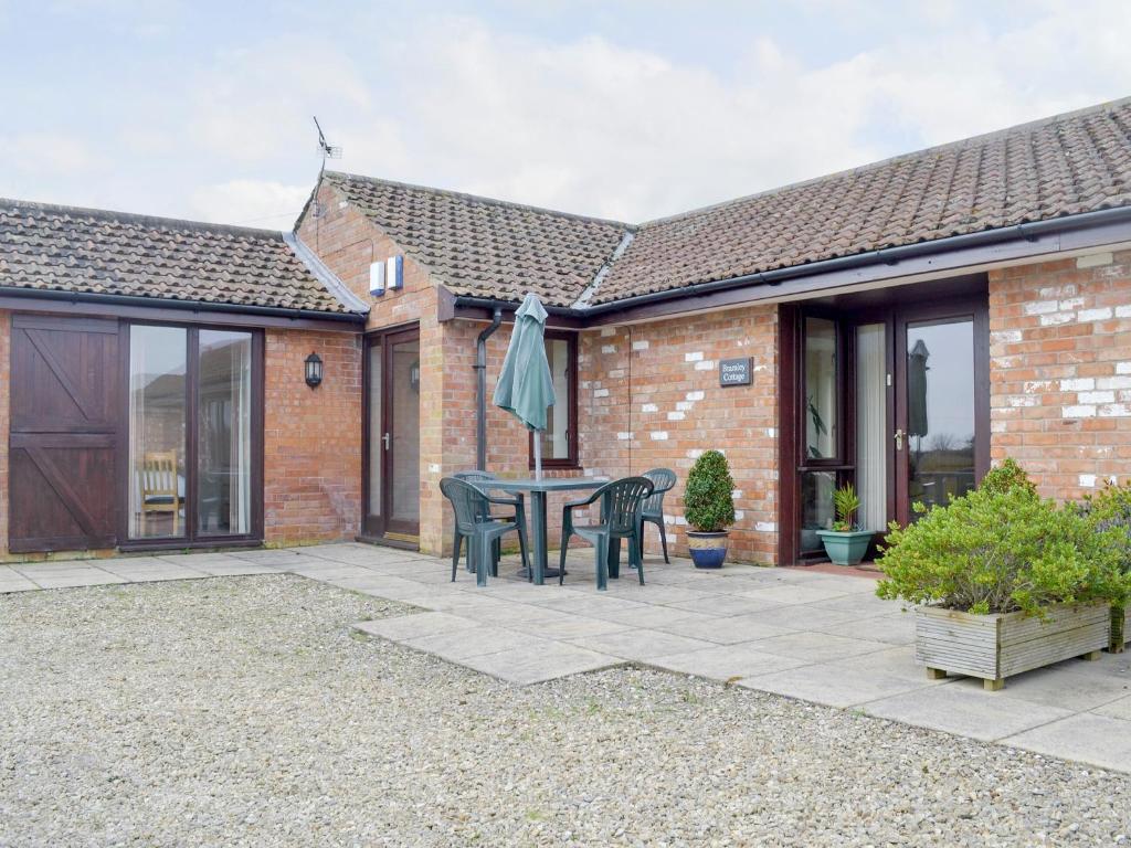 a patio with a table and chairs in front of a house at Bramley Cottage in Brean