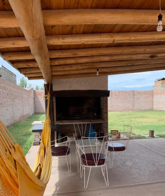 un patio con hamaca, mesa y sillas en La casita en San Rafael