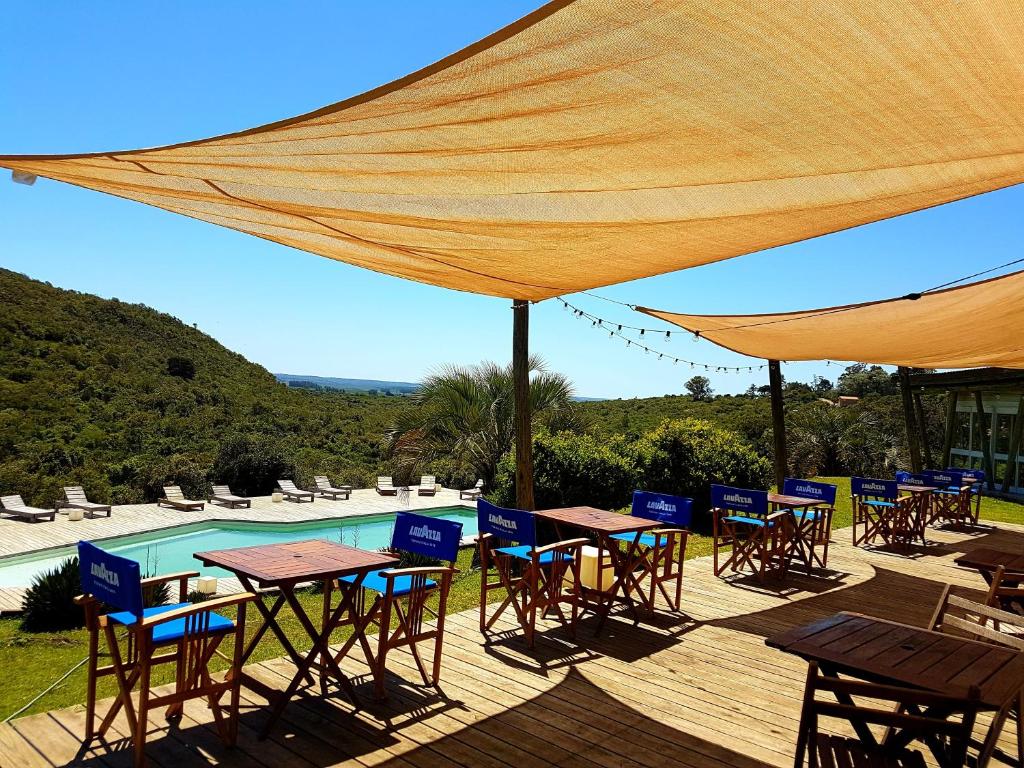 un patio con mesas y sillas y una piscina en Villa Serrana - Mesón de las cañas, en Villa Serrana