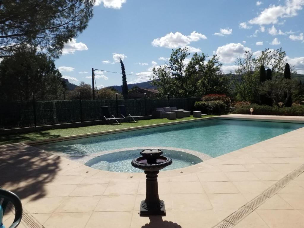 une piscine avec un bain d'oiseaux devant dans l'établissement Nos penates, à Bagnols-en-Forêt