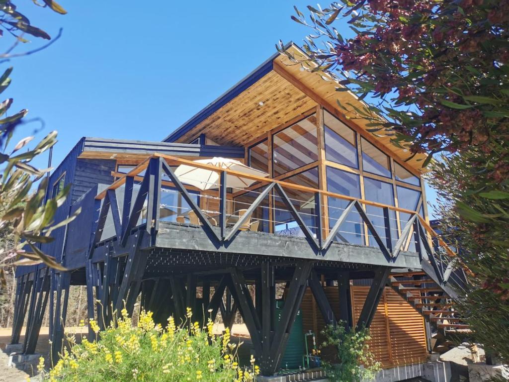 a house on a wooden structure with windows at Loica in Pichilemu