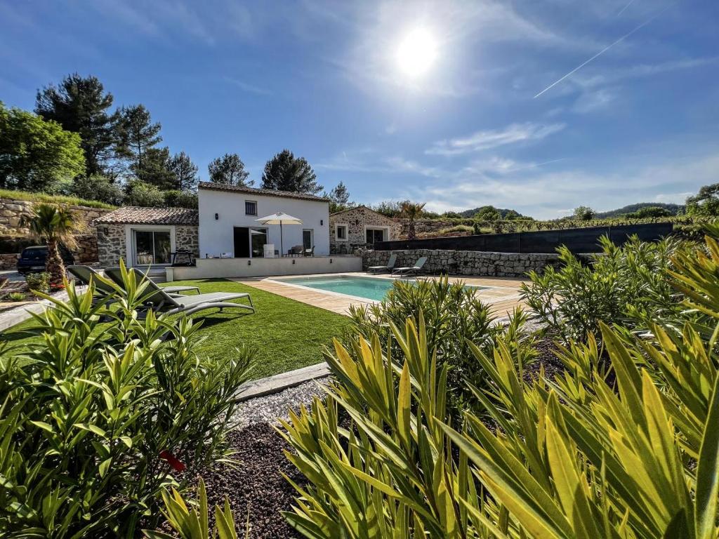 a house with a swimming pool and a yard at La maurette piscine chauffee in La Motte