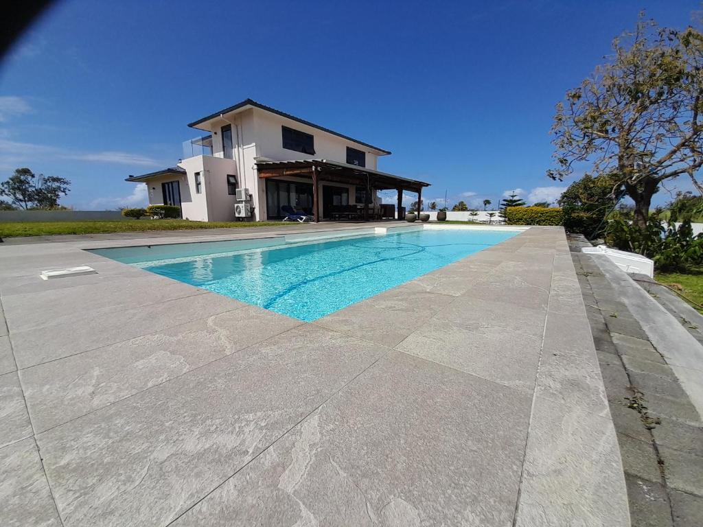 a swimming pool in front of a house at Jags villa in Plaine Magnien
