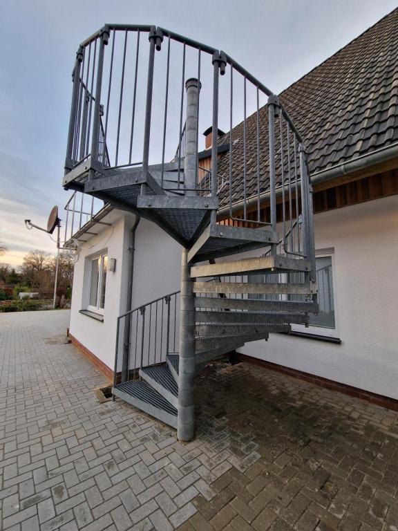 una escalera de caracol en el lateral de una casa en Ferienwohnung Olaf, en Schneverdingen
