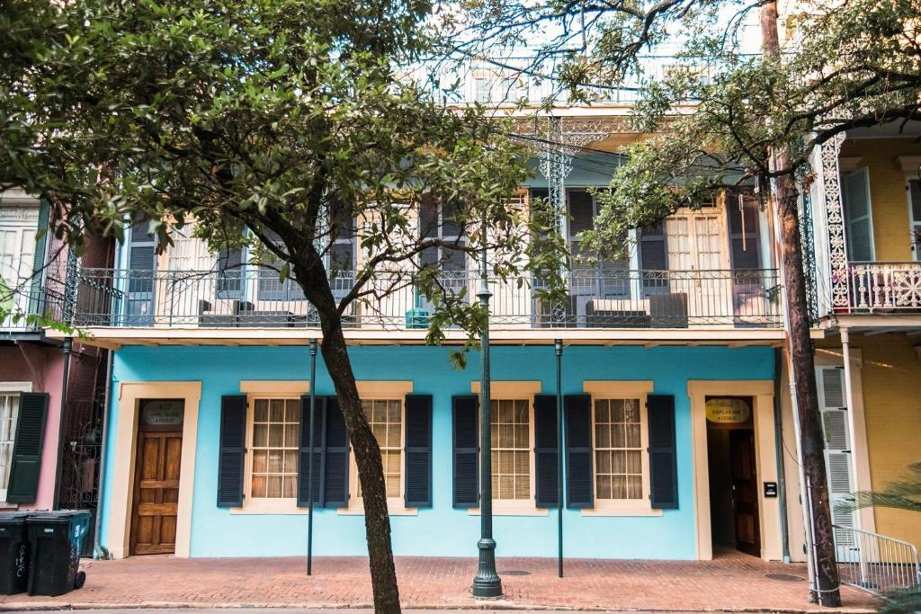 un edificio azul con ventanas blancas en una calle en Jean Lafitte House en Nueva Orleans