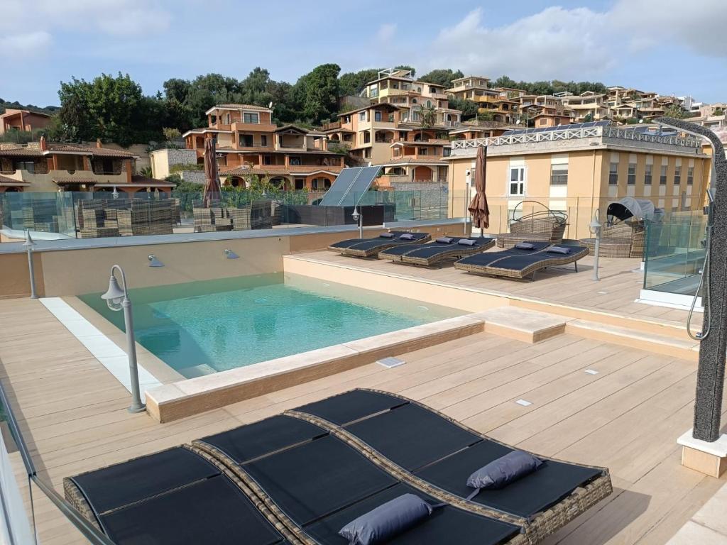 a swimming pool with lounge chairs on a roof at Crabonaxa Suite Appartment in Villasimius