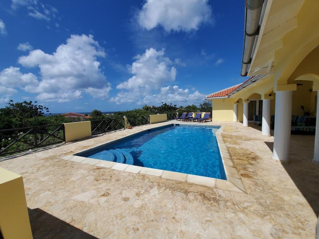 a swimming pool in the backyard of a house at Private Family Paradise Villa Ocean View With Private Pool in Kralendijk