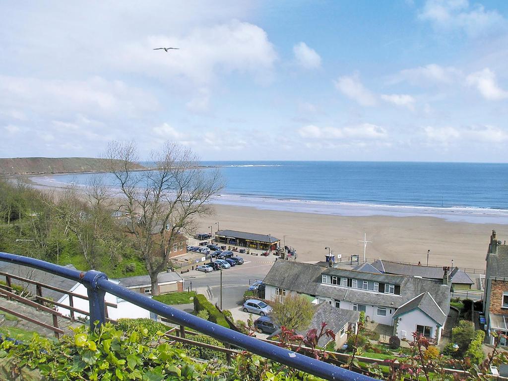 a view of a beach with a bird flying over it at Billy Napps Cottage in Filey