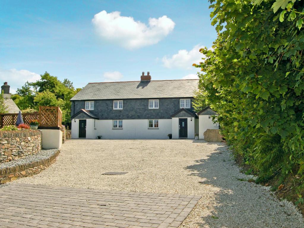 a large house with a driveway in front of it at Home Park Farm Cottages A in Lanteglos