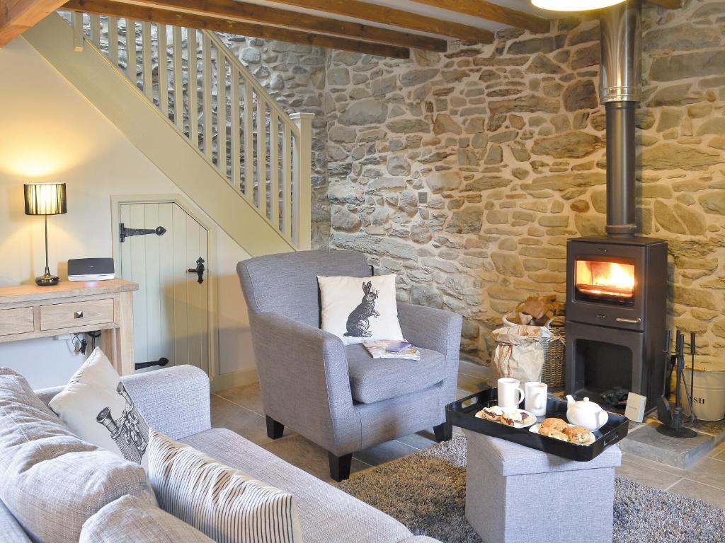 a living room with a couch and a wood stove at Ivy Bush Cottage in Llanddewi-Brefi