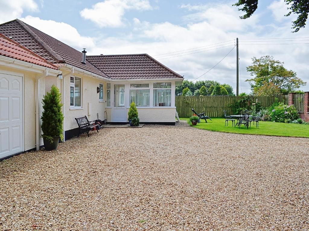 a house with a gravel driveway in front of it at South Cleeve Bungalow in Otterford