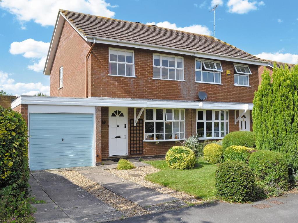 a red brick house with a white garage at Hanson Avenue in Honington