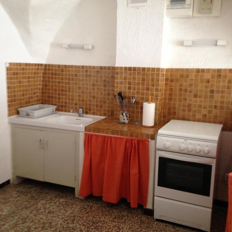 une cuisine avec un évier et une cuisinière dans l'établissement La forge, à Moissac-Bellevue