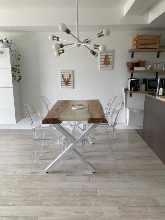 een eetkamer met een houten tafel en stoelen bij Le Haven in MSA in Beaupré