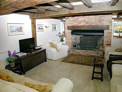 a living room with a couch and a fireplace at Thornsdale Oast House in Stone