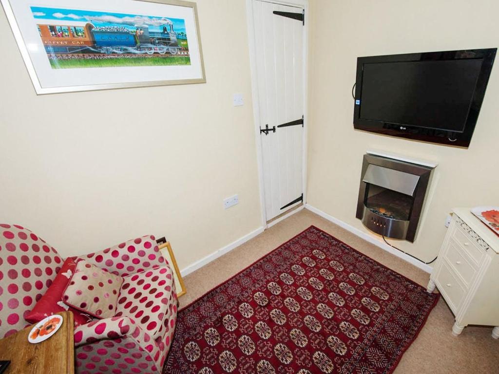 een woonkamer met een bank en een flatscreen-tv bij Cobble Cottage30c - Ukc2846 in Blakeney