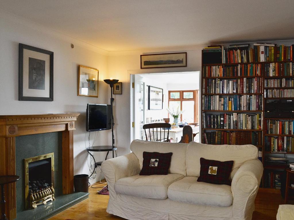 sala de estar con sofá blanco y chimenea en Endeavours End, en Gatehouse of Fleet