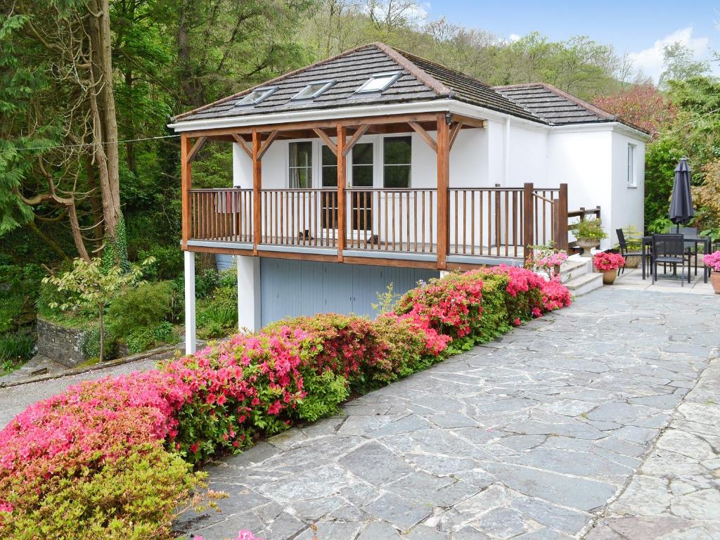 a gazebo with flowers in front of a house at River Lodge in Polperro