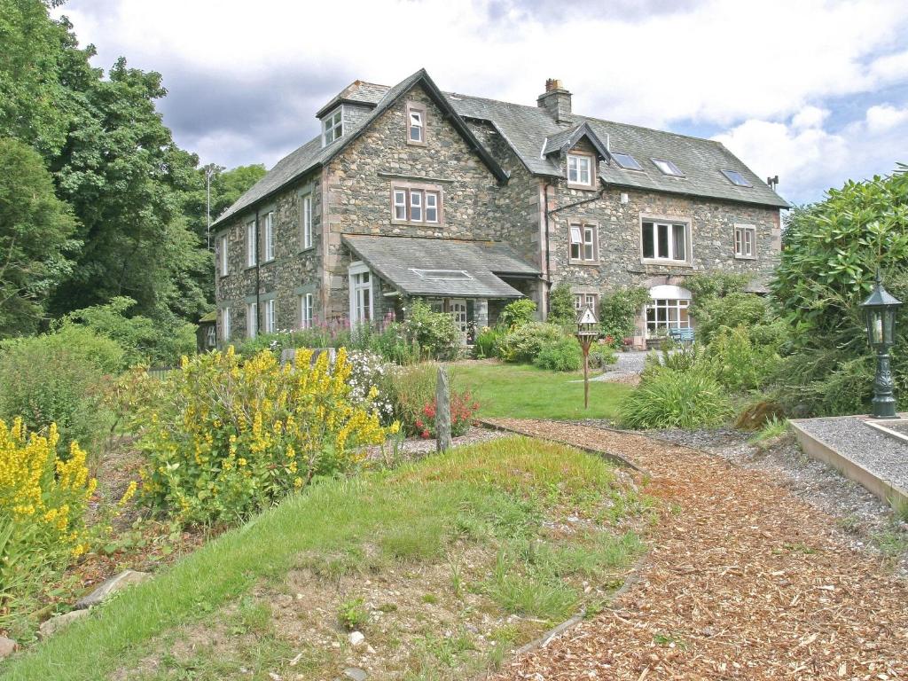 une ancienne maison en pierre avec un jardin en face de celle-ci dans l'établissement High Rigg, à Keswick