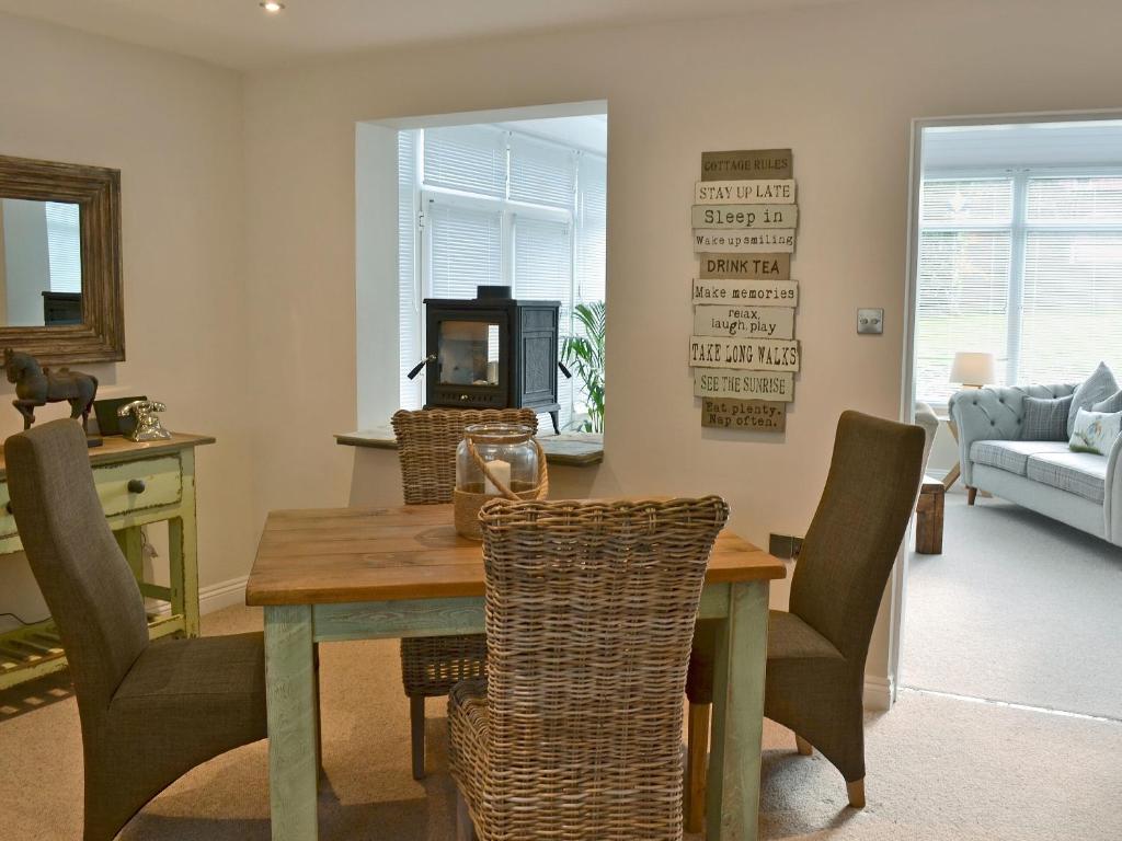 a dining room with a table and chairs at Elm Tree Cottage in Foxholes