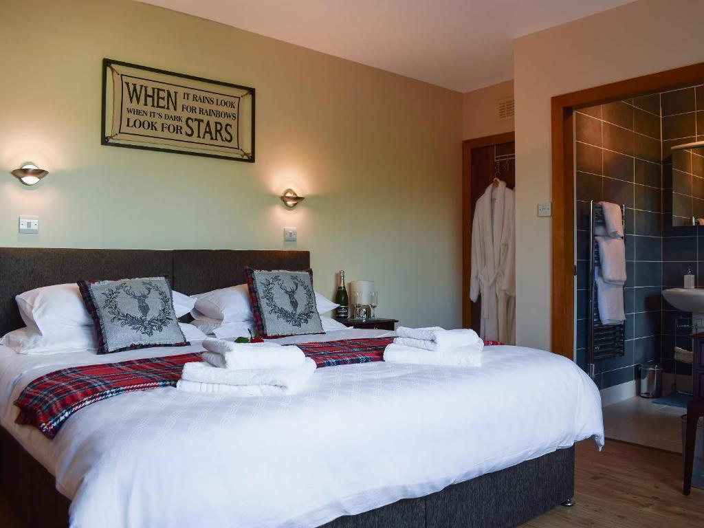 a bedroom with a large bed with towels on it at St Andrews Hideaway in St. Andrews